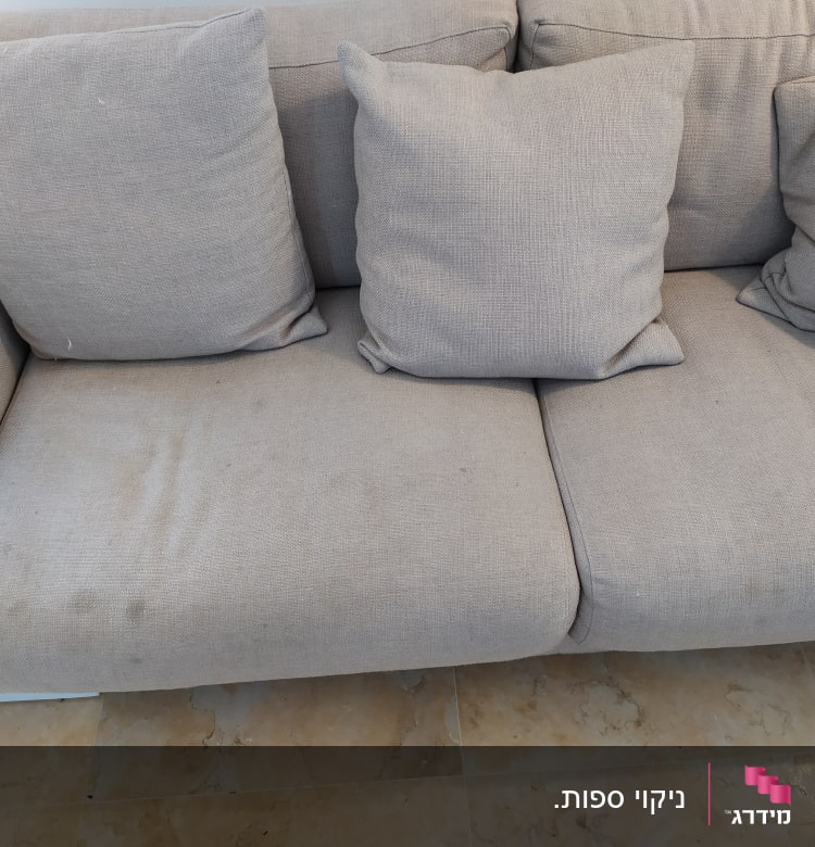 ספה אפורה עם כתמים על המושב